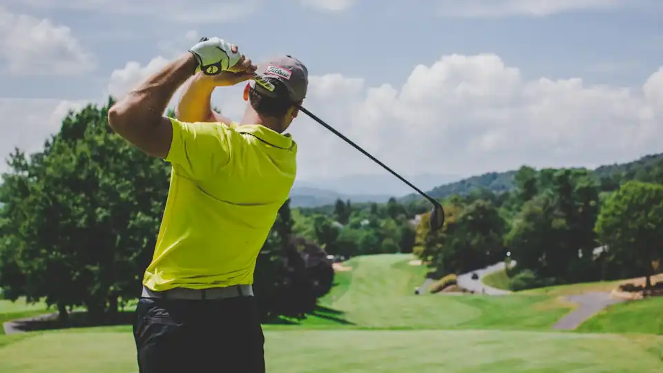 Golfer watching his tee shot fly down the fairway
